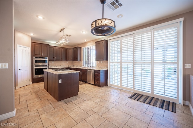 kitchen featuring appliances with stainless steel finishes, dark brown cabinets, a center island, and decorative light fixtures