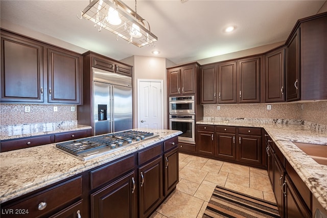 kitchen with dark brown cabinets, stainless steel appliances, tasteful backsplash, and pendant lighting