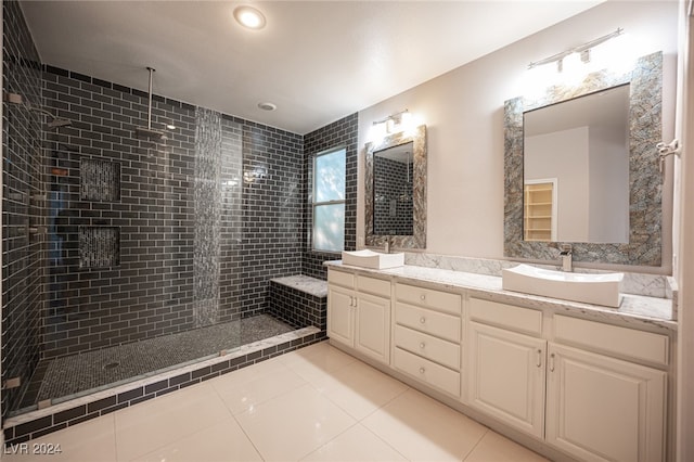 bathroom featuring vanity, tiled shower, and tile patterned flooring