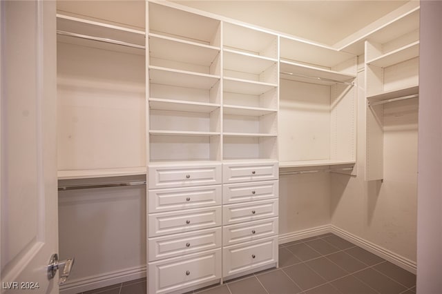 walk in closet with dark tile patterned floors