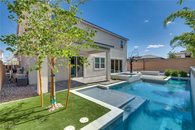 view of pool with an in ground hot tub, a yard, and a patio area