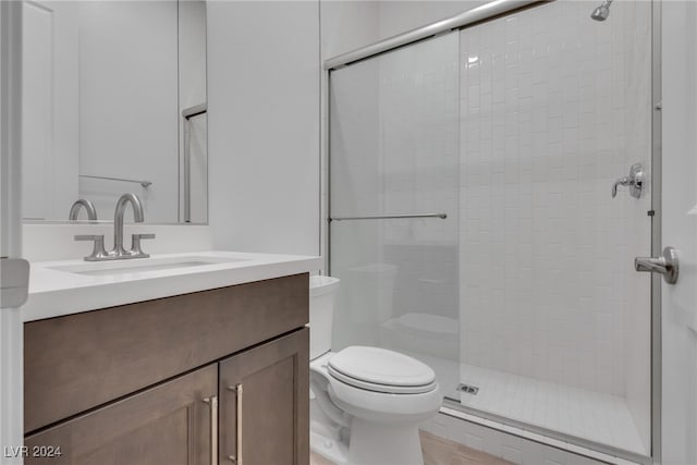 bathroom featuring tile patterned flooring, an enclosed shower, vanity, and toilet