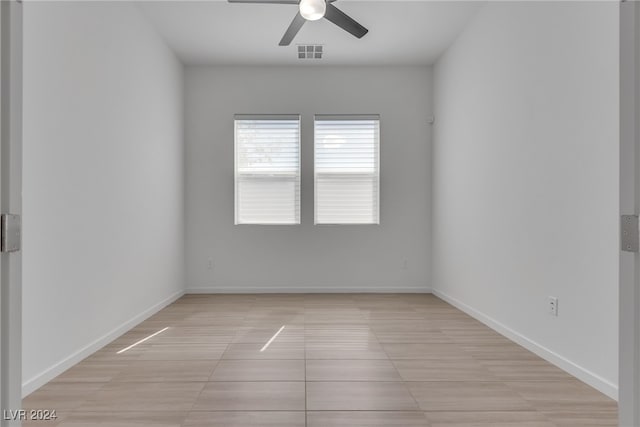 tiled spare room with ceiling fan