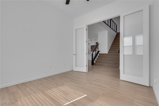 spare room featuring ceiling fan and french doors