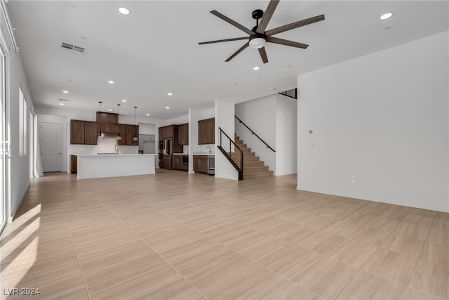 unfurnished living room featuring ceiling fan and light tile patterned flooring