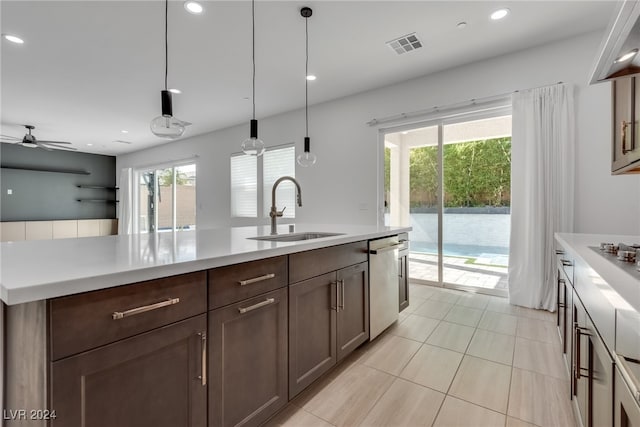 kitchen featuring light tile patterned floors, pendant lighting, ceiling fan, stainless steel dishwasher, and sink