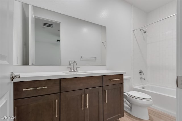 full bathroom with tiled shower / bath combo, vanity, toilet, and hardwood / wood-style floors