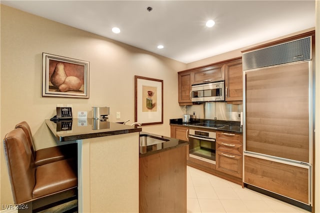 kitchen featuring appliances with stainless steel finishes, kitchen peninsula, a breakfast bar area, and sink