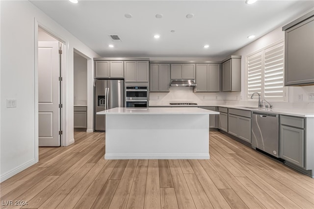 kitchen featuring light hardwood / wood-style flooring, a center island, appliances with stainless steel finishes, and sink