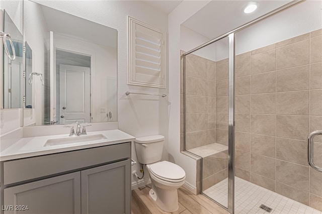 bathroom with an enclosed shower, hardwood / wood-style flooring, vanity, and toilet