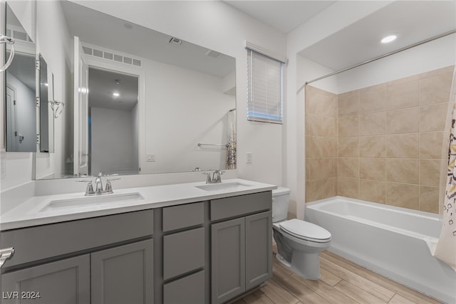 full bathroom featuring wood-type flooring, vanity, shower / tub combo, and toilet