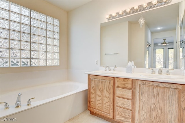 bathroom featuring ceiling fan, vanity, and a bathing tub