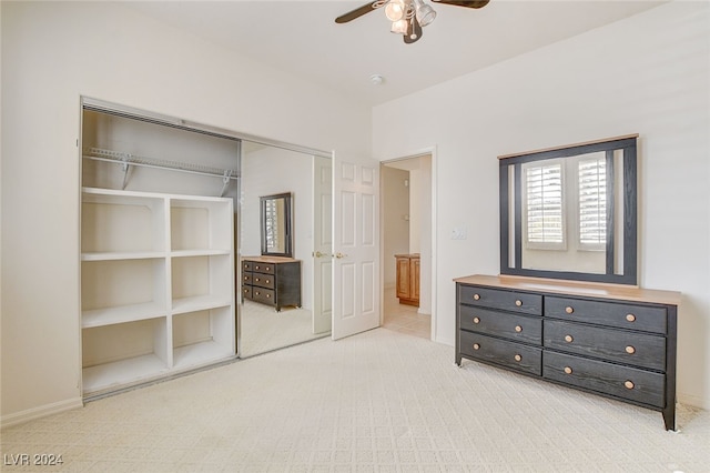 unfurnished bedroom featuring light carpet, a closet, and ceiling fan