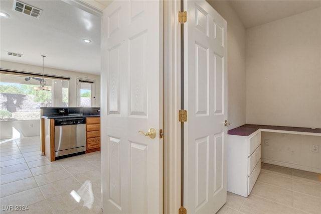 kitchen with pendant lighting, a notable chandelier, light tile patterned flooring, and stainless steel dishwasher