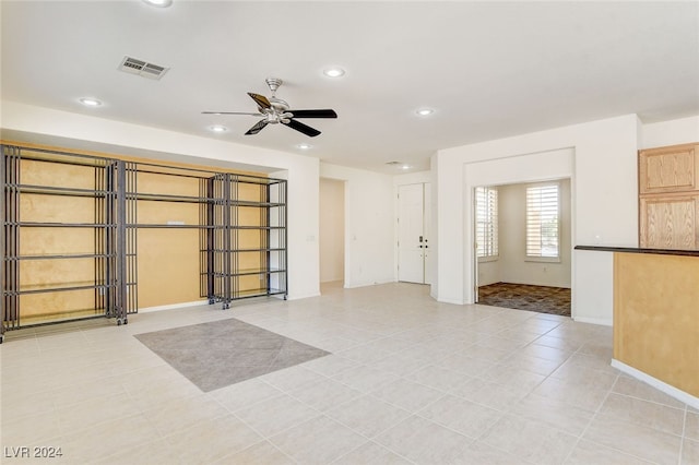 interior space with light tile patterned floors and ceiling fan