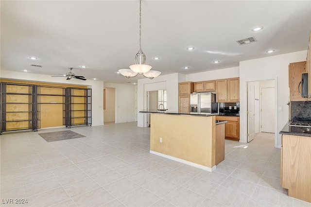 kitchen with pendant lighting, light tile patterned floors, stainless steel fridge with ice dispenser, ceiling fan with notable chandelier, and decorative backsplash