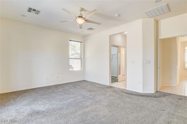 spare room with ceiling fan and light colored carpet