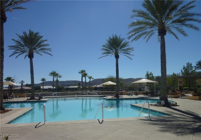 view of swimming pool featuring a patio and a mountain view