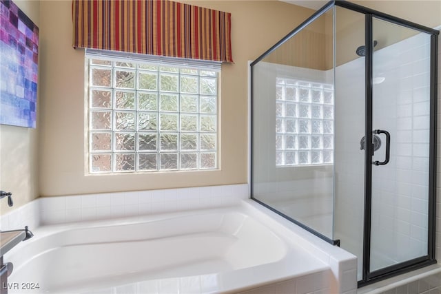 bathroom featuring shower with separate bathtub