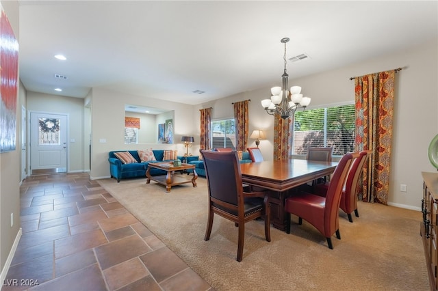 dining area with an inviting chandelier and dark carpet