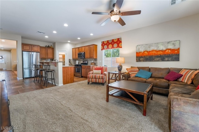 carpeted living room with ceiling fan