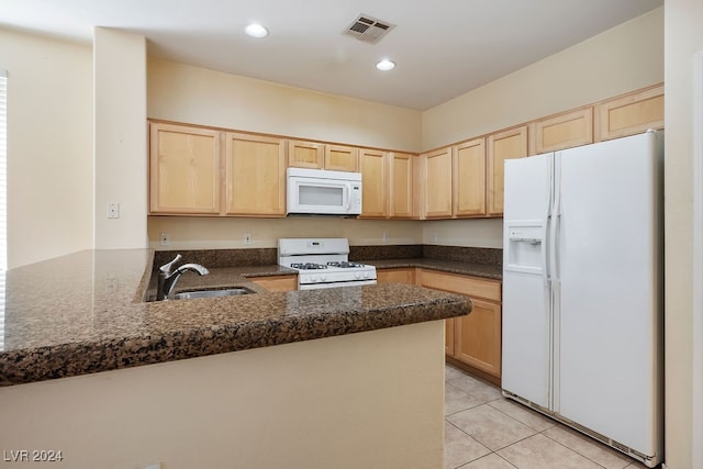 kitchen featuring light tile patterned floors, sink, kitchen peninsula, white appliances, and light brown cabinetry