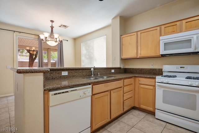 kitchen with white appliances, kitchen peninsula, light tile patterned floors, an inviting chandelier, and sink