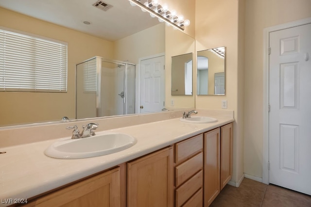 bathroom featuring tile patterned flooring, vanity, and an enclosed shower