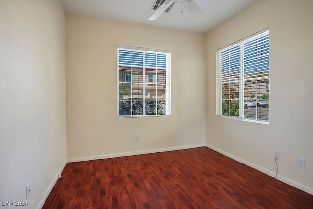 unfurnished room featuring ceiling fan, dark hardwood / wood-style floors, and a wealth of natural light