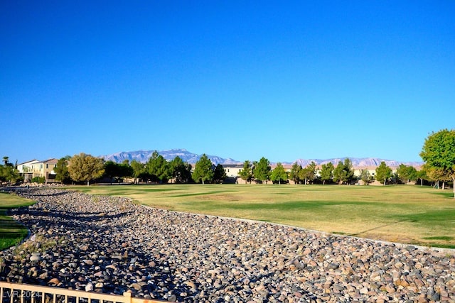 surrounding community with a lawn and a mountain view