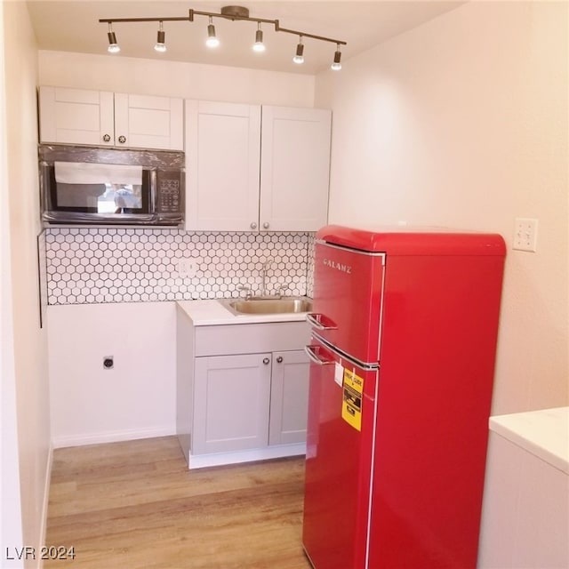 kitchen featuring light wood-type flooring, stainless steel fridge, decorative backsplash, and white cabinets