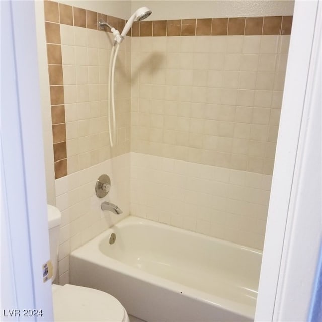 bathroom with tiled shower / bath and toilet