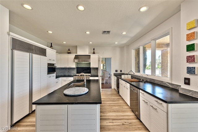 kitchen with dark countertops, visible vents, white cabinets, and dishwasher