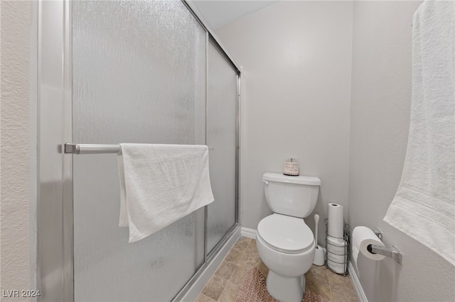 bathroom featuring toilet and an enclosed shower