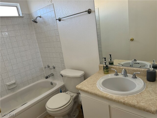 full bathroom with vanity, tiled shower / bath combo, and toilet