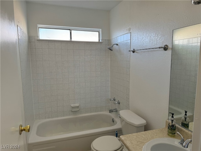 full bathroom featuring vanity, tiled shower / bath combo, and toilet