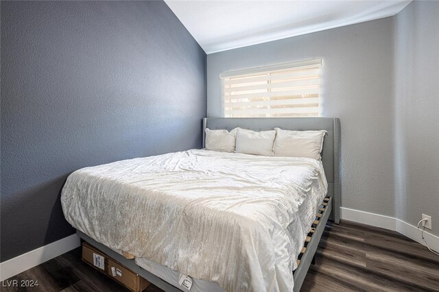 bedroom with vaulted ceiling and dark hardwood / wood-style flooring