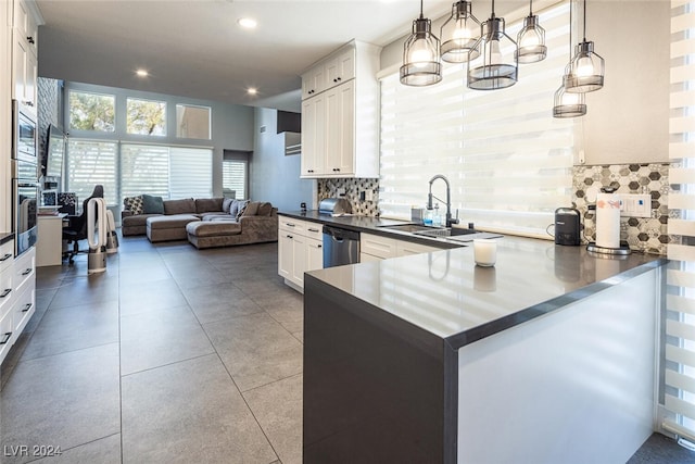 kitchen featuring pendant lighting, white cabinetry, kitchen peninsula, and tasteful backsplash