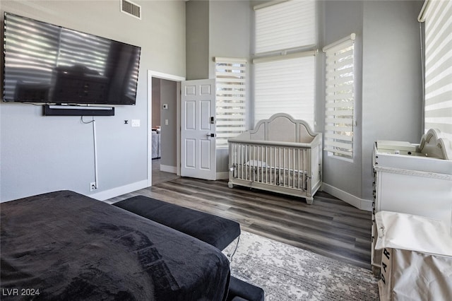 bedroom with dark hardwood / wood-style flooring and a high ceiling