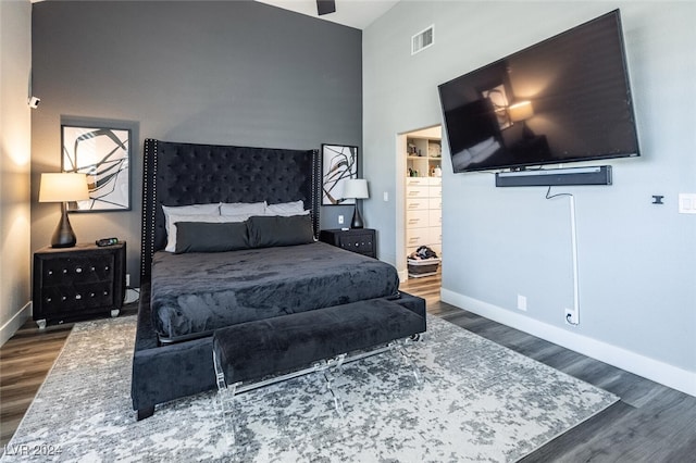 bedroom with dark wood-type flooring and high vaulted ceiling