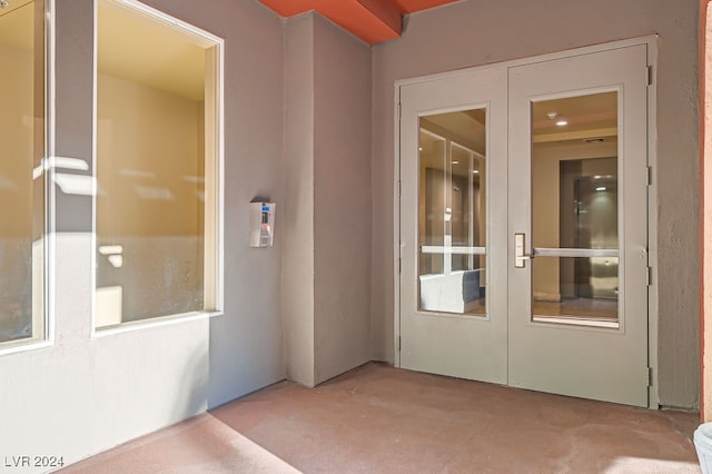 view of exterior entry featuring french doors and a patio