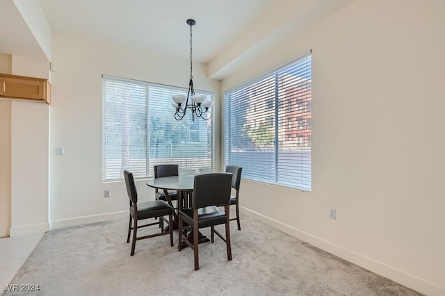 dining area featuring light carpet and a chandelier