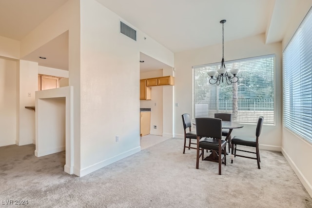 carpeted dining room with an inviting chandelier