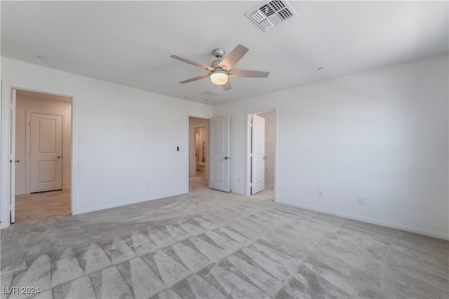 empty room featuring light carpet, visible vents, and a ceiling fan