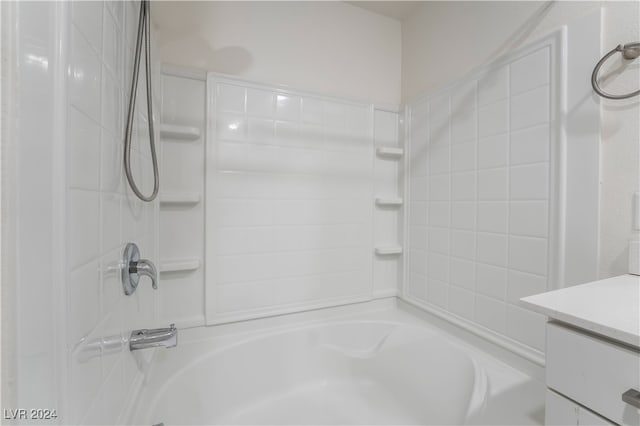 bathroom featuring vanity and tiled shower / bath