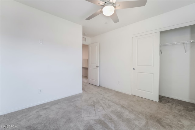 unfurnished bedroom with ceiling fan, a closet, and light colored carpet