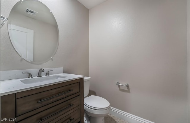 bathroom featuring visible vents, baseboards, vanity, and toilet