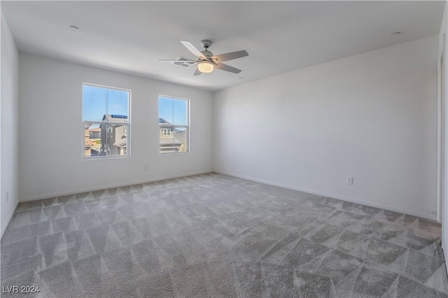 empty room with carpet flooring, ceiling fan, and baseboards