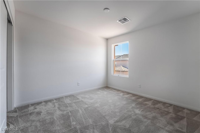 unfurnished room with carpet floors, baseboards, and visible vents