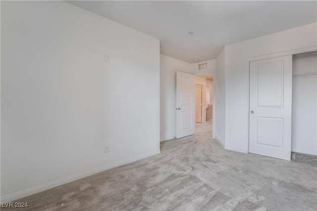 unfurnished bedroom featuring a closet, carpet flooring, visible vents, and baseboards